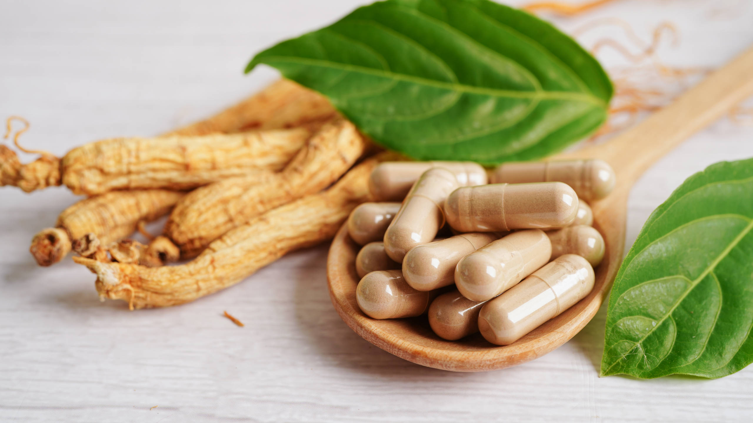 Ginseng roots and encapsulated ginseng on a spoon